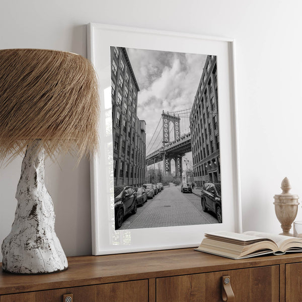 Framed Manhattan Bridge photography print in Dumbo Brooklyn with cobblestone street and monochrome architecture