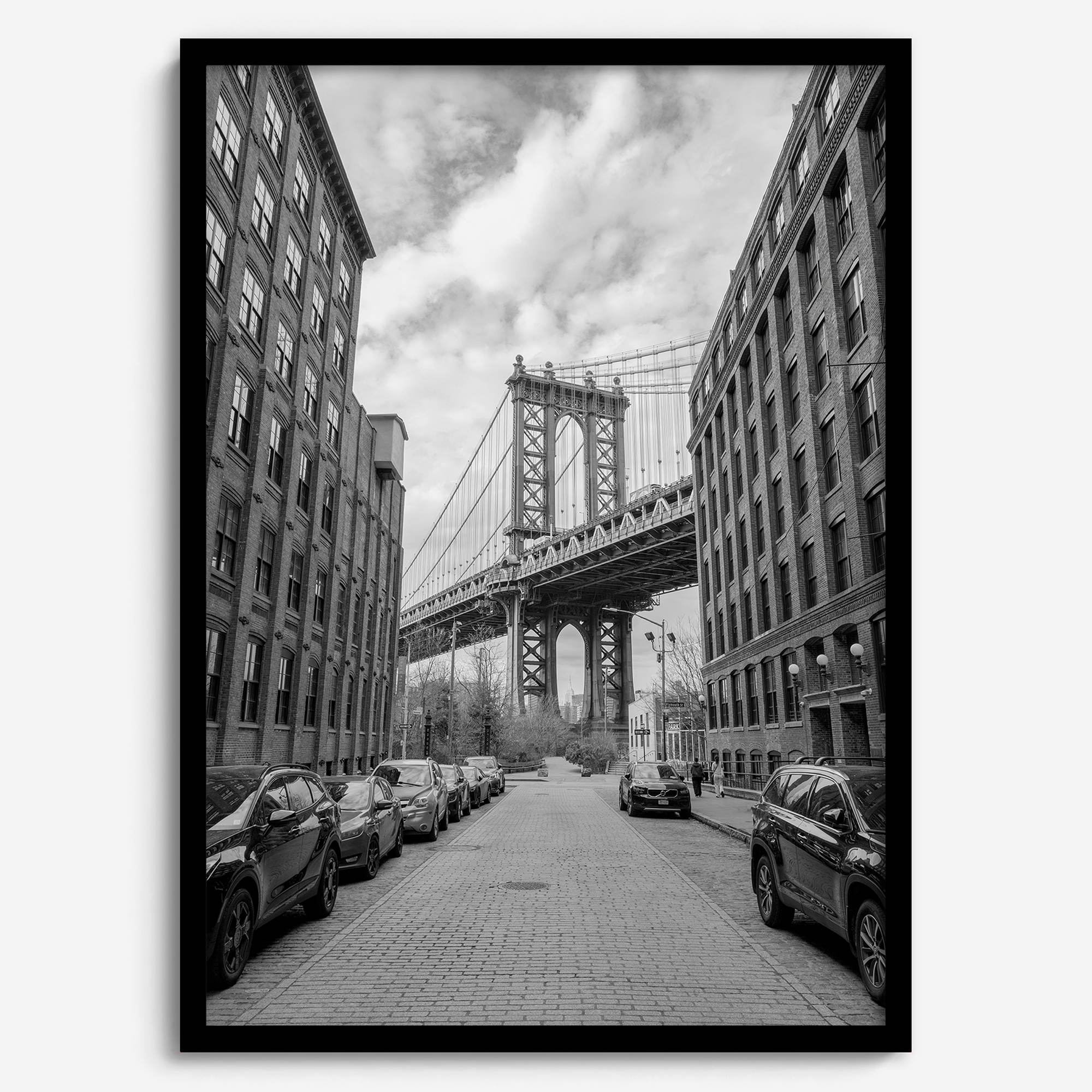 Framed Manhattan Bridge photography print in Dumbo Brooklyn with cobblestone street and monochrome architecture