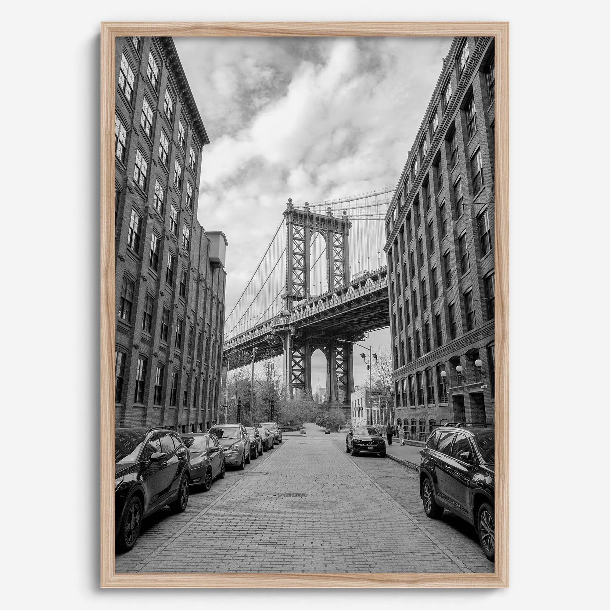 Framed Manhattan Bridge photography print in Dumbo Brooklyn with cobblestone street and monochrome architecture