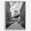 Framed Manhattan Bridge photography print in Dumbo Brooklyn with cobblestone street and monochrome architecture