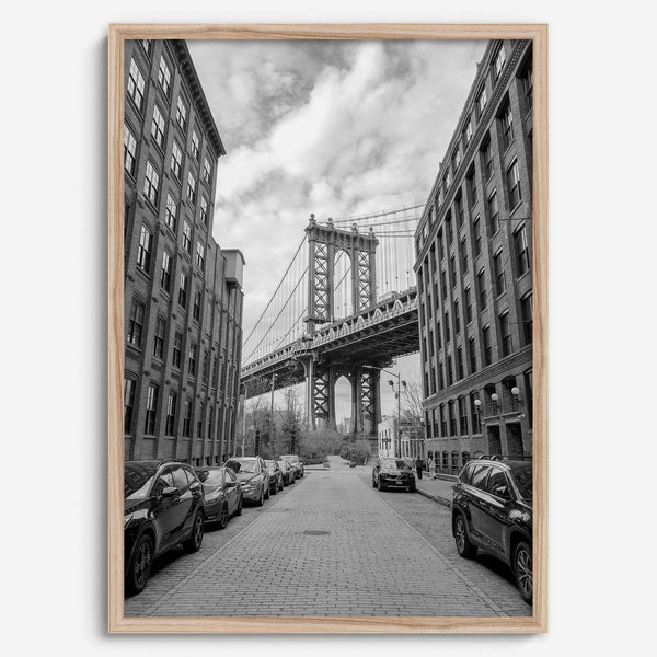 Framed Manhattan Bridge photography print in Dumbo Brooklyn with cobblestone street and monochrome architecture