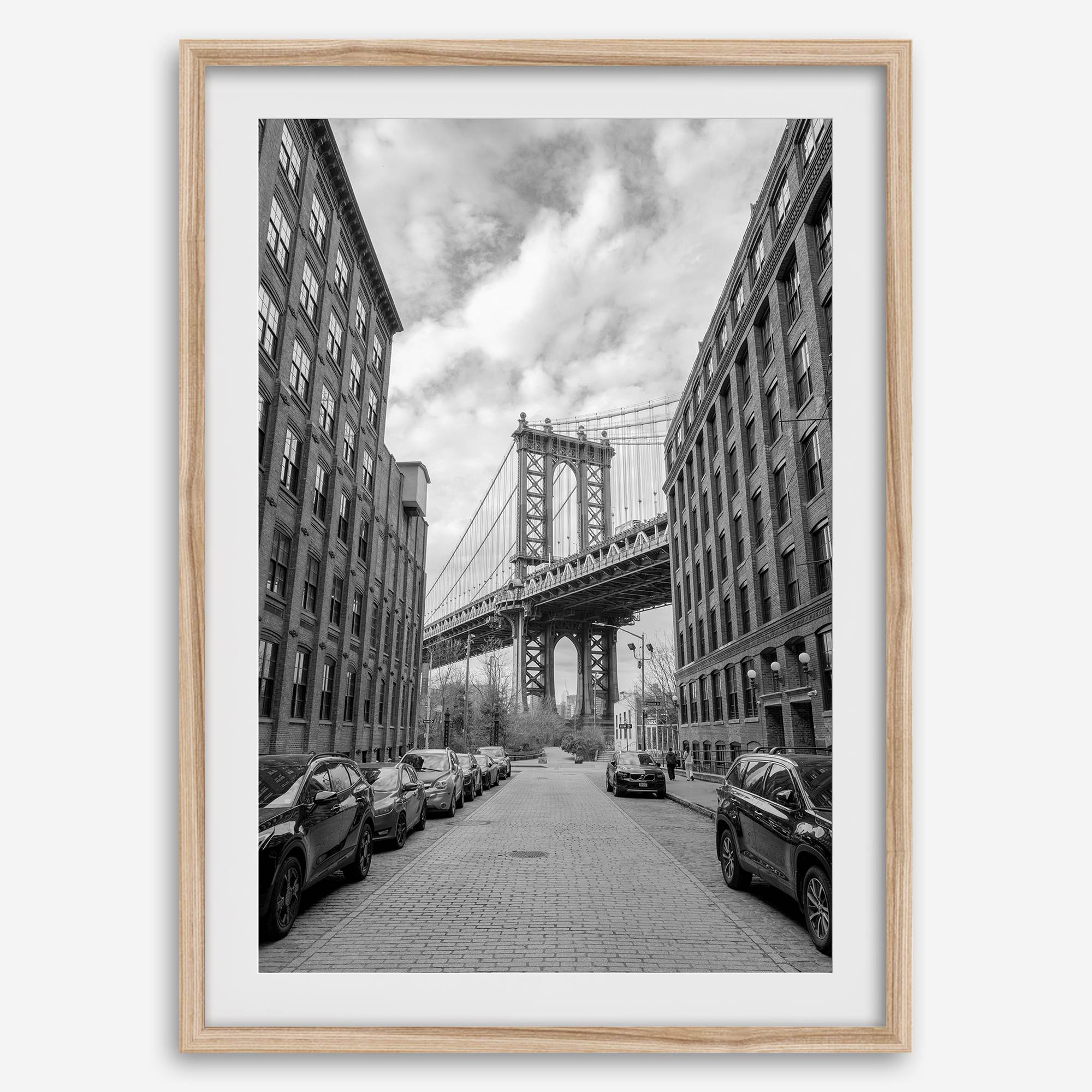 Framed Manhattan Bridge photography print in Dumbo Brooklyn with cobblestone street and monochrome architecture