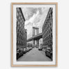Framed Manhattan Bridge photography print in Dumbo Brooklyn with cobblestone street and monochrome architecture