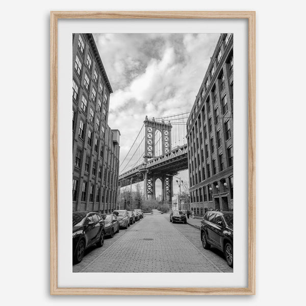 Framed Manhattan Bridge photography print in Dumbo Brooklyn with cobblestone street and monochrome architecture