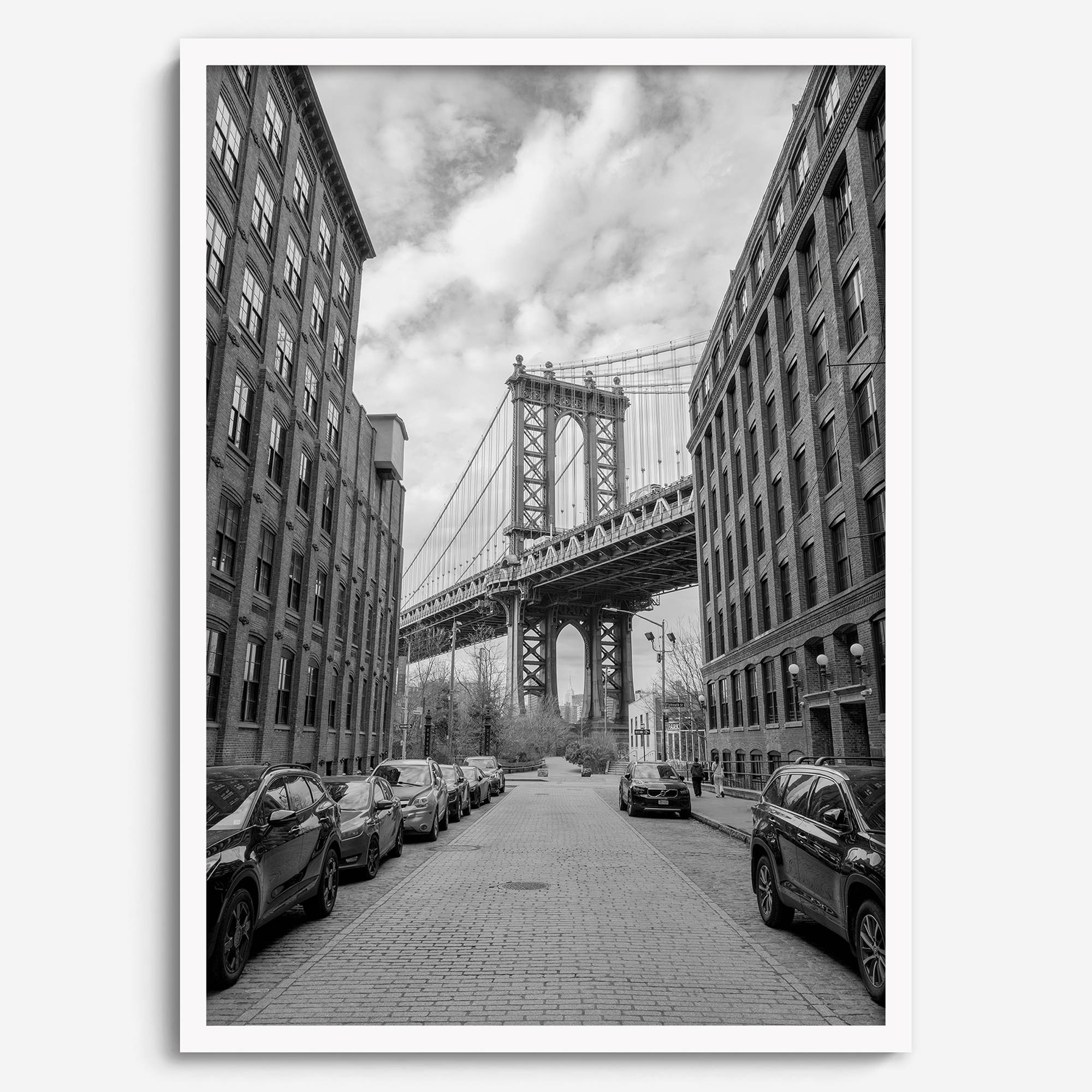 Framed Manhattan Bridge photography print in Dumbo Brooklyn with cobblestone street and monochrome architecture