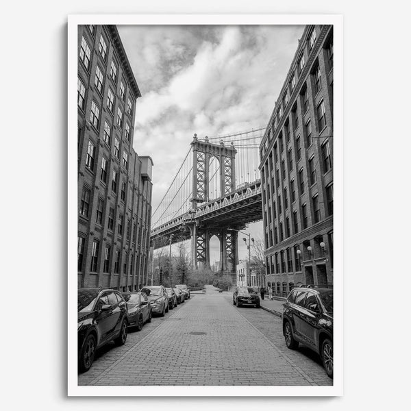 Framed Manhattan Bridge photography print in Dumbo Brooklyn with cobblestone street and monochrome architecture
