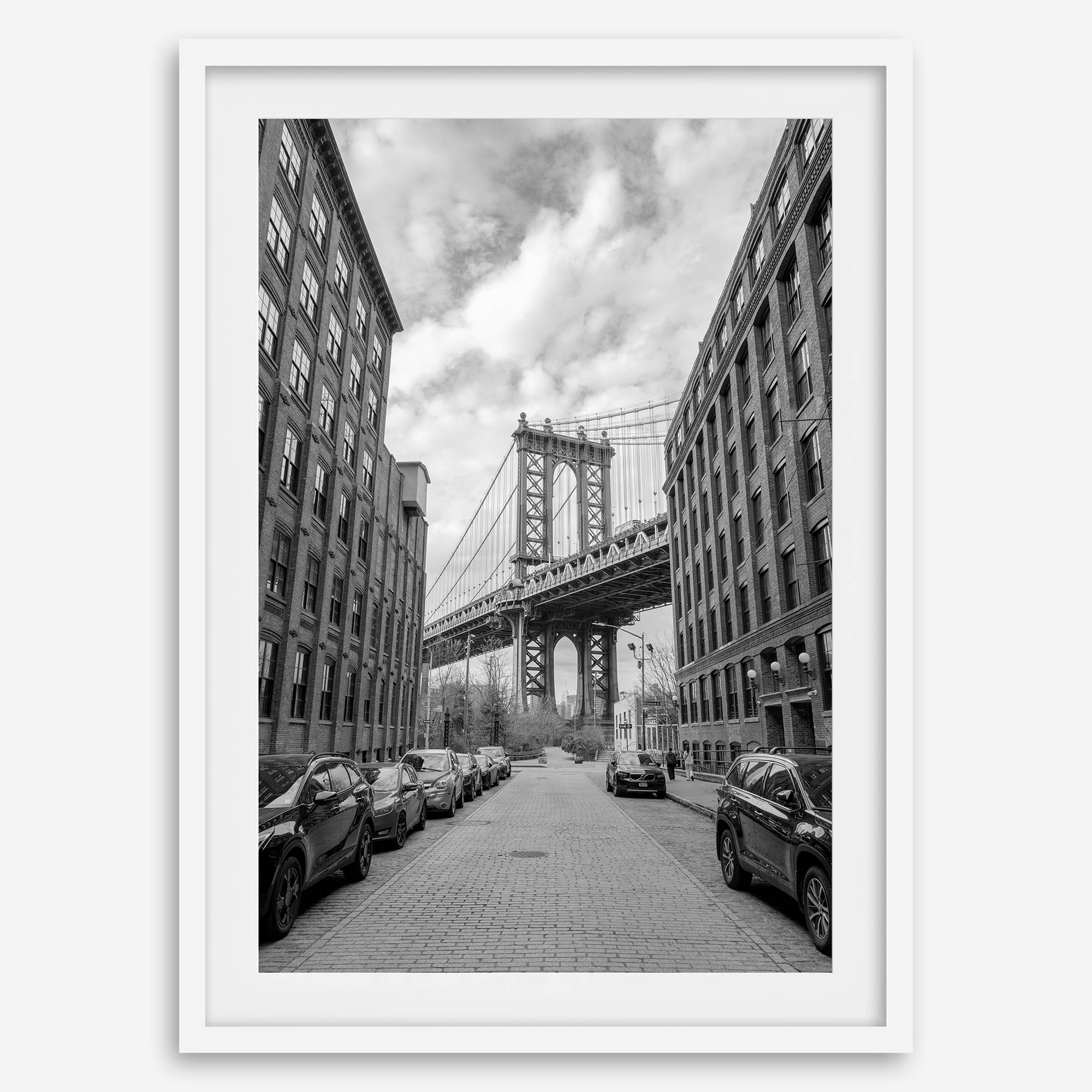 Framed Manhattan Bridge photography print in Dumbo Brooklyn with cobblestone street and monochrome architecture