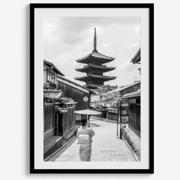 Timeless Kyoto scene with traditional architecture and kimono-clad woman in black and white.