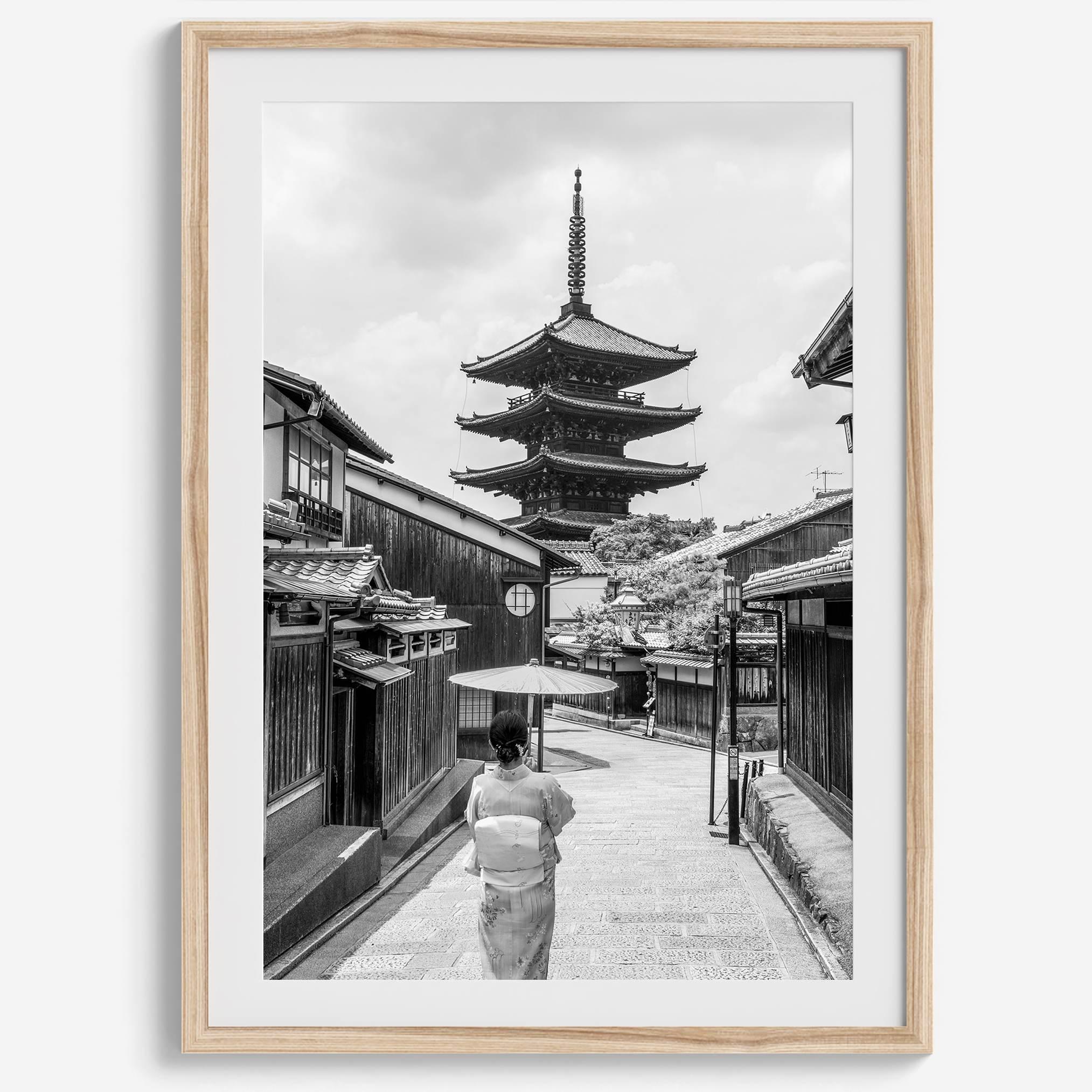 Timeless Kyoto scene with traditional architecture and kimono-clad woman in black and white.