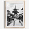 Timeless Kyoto scene with traditional architecture and kimono-clad woman in black and white.