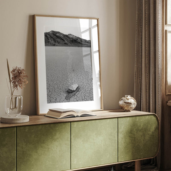 Fine art mojave print showing a sailing stone on Racetrack Playa in Death Valley with mountains in the background.