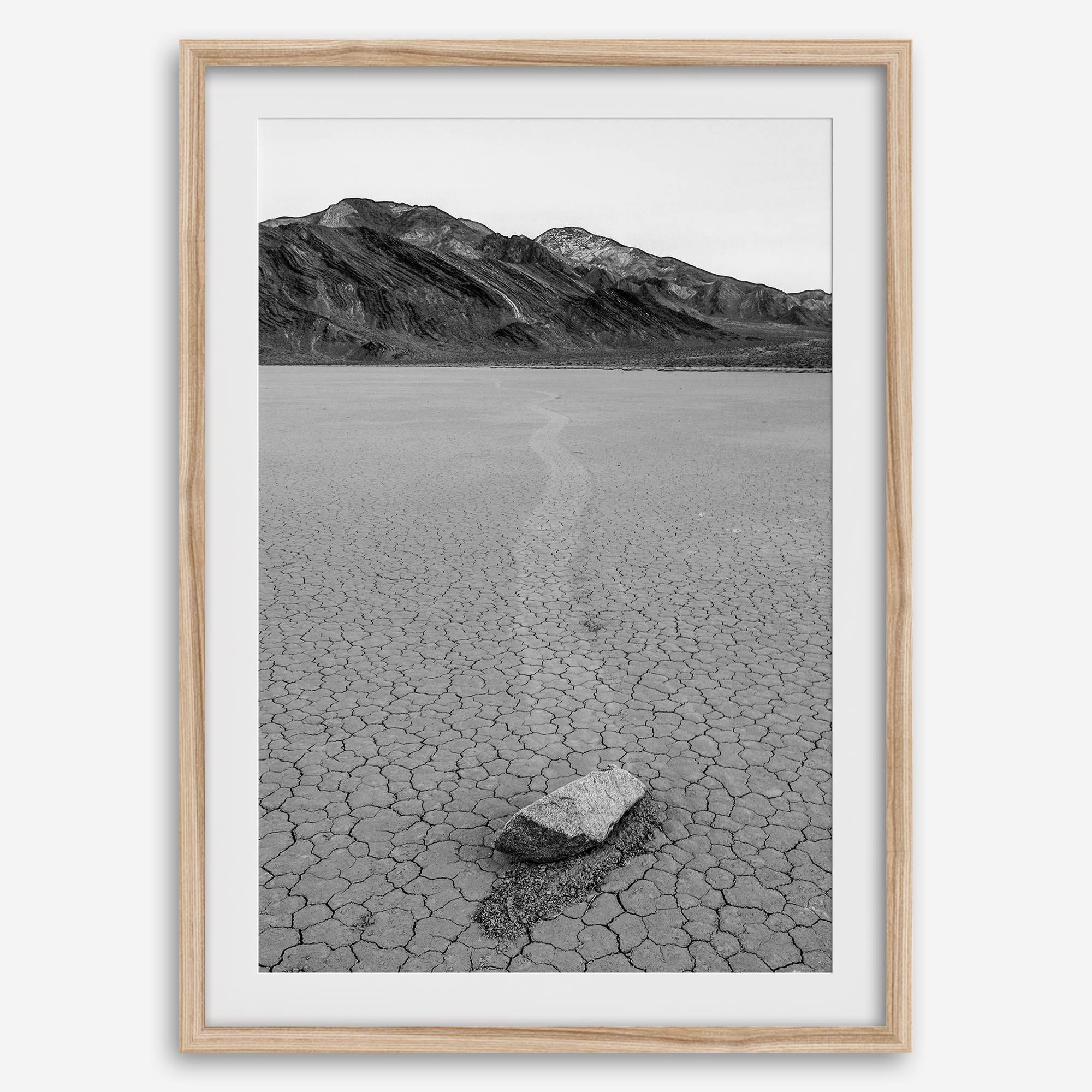 Fine art mojave print showing a sailing stone on Racetrack Playa in Death Valley with mountains in the background.