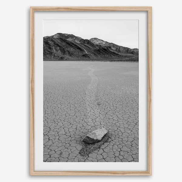 Fine art mojave print showing a sailing stone on Racetrack Playa in Death Valley with mountains in the background.