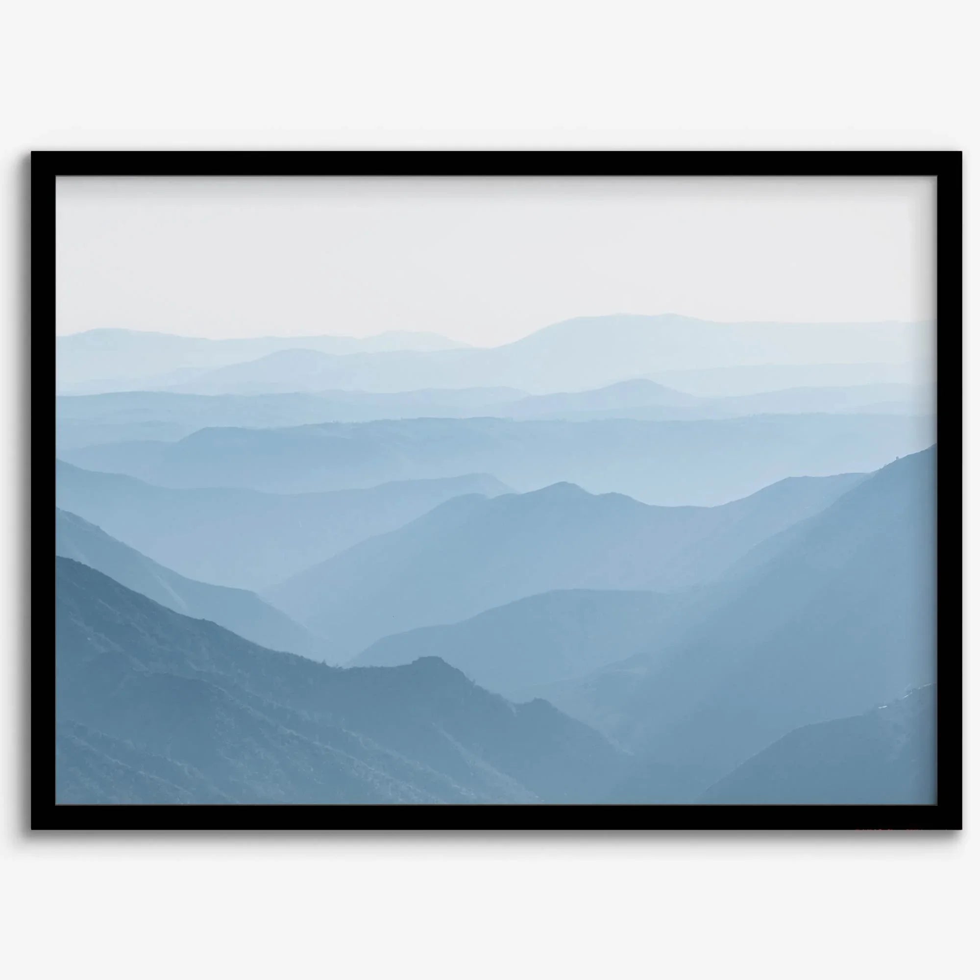 A fine art mountain photography print showing tens of shaded mountains one after the other. This minimalist mountain range wall art is perfect for nature lovers.
