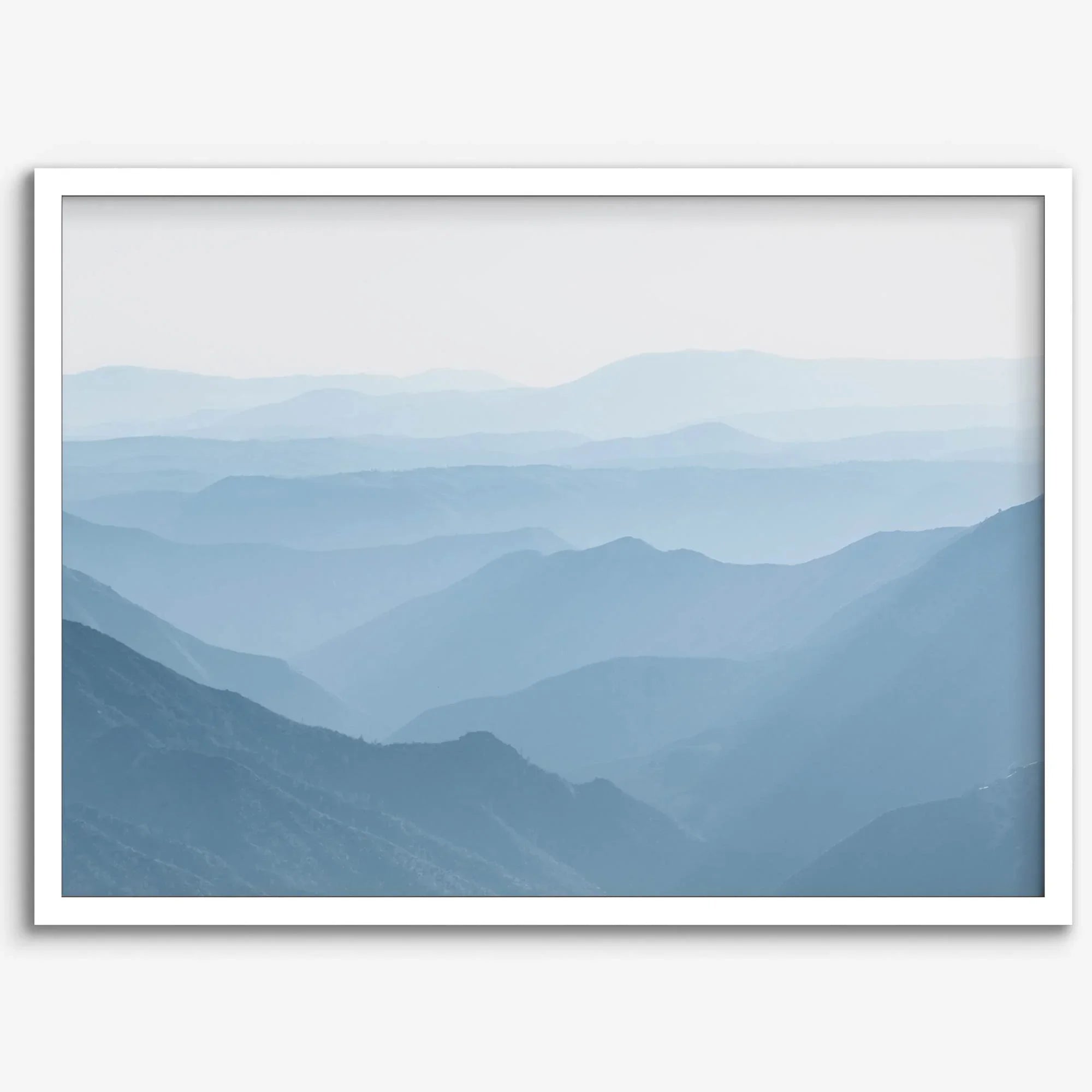 A fine art mountain photography print showing tens of shaded mountains one after the other. This minimalist mountain range wall art is perfect for nature lovers.