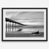 Ocean Beach Pier San Diego photographed in black and white with a lone surfer resting on the shoreline.