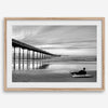 Ocean Beach Pier San Diego photographed in black and white with a lone surfer resting on the shoreline.