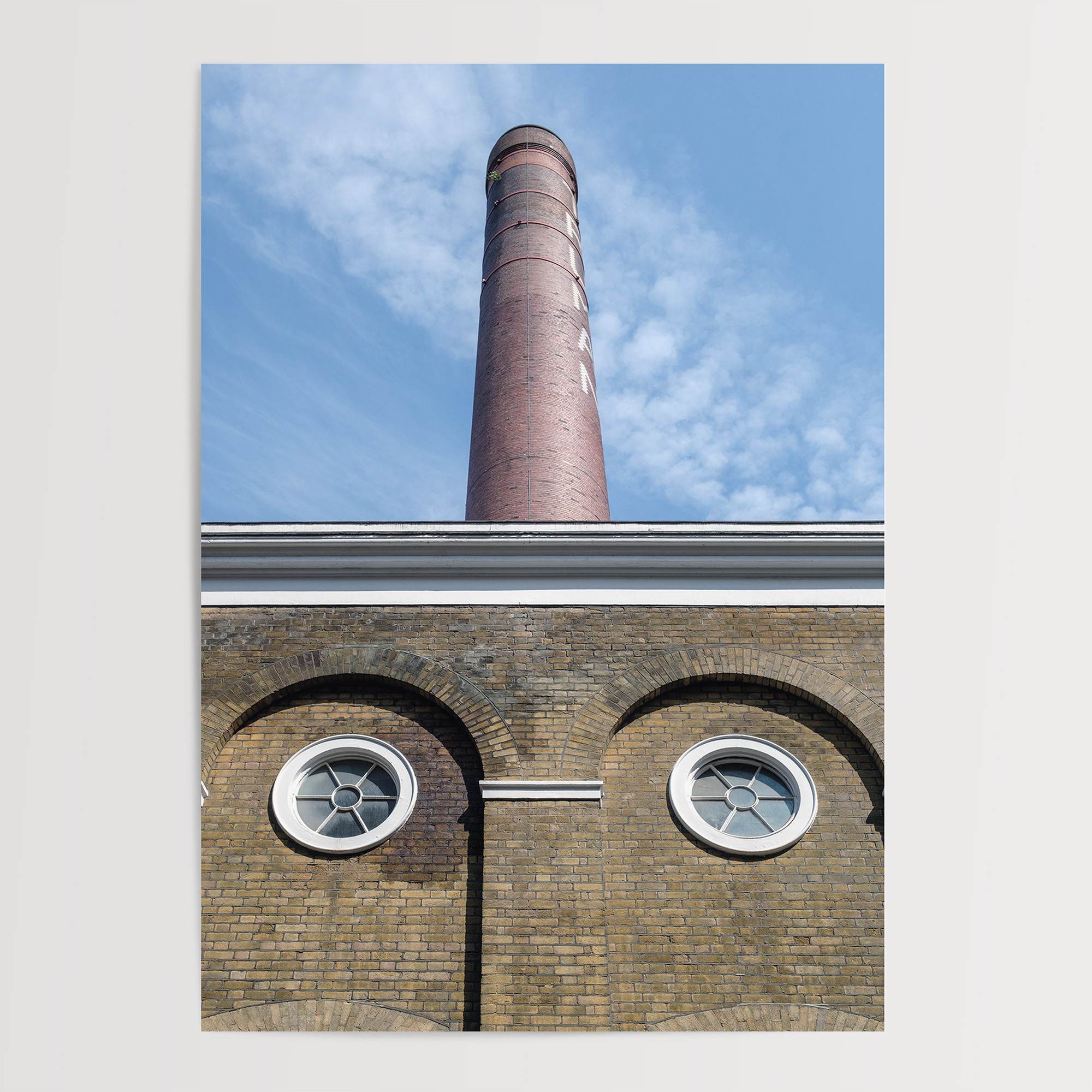 Vertical photography of the Old Truman Brewery chimney in Shoreditch with windows resembling eyes.