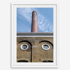 Vertical photography of the Old Truman Brewery chimney in Shoreditch with windows resembling eyes.