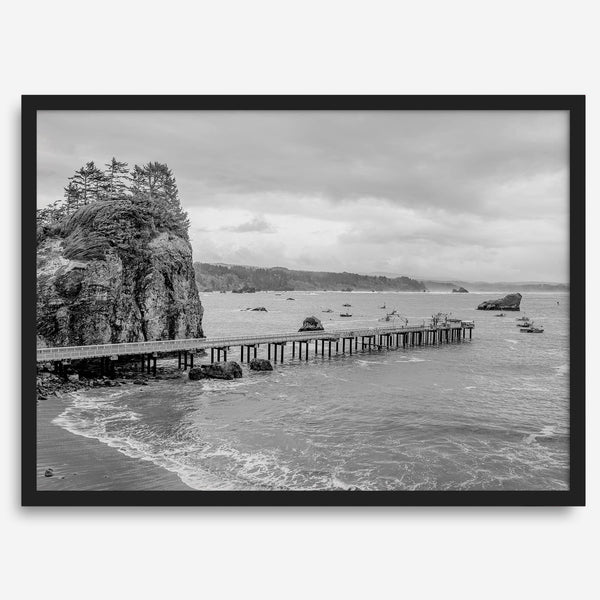 Scenic Pacific Northwest wall art of Trinidad State Park in California in black and white, showcasing a coastal pier, lush green cliffs, and calm ocean waves under cloudy skies.