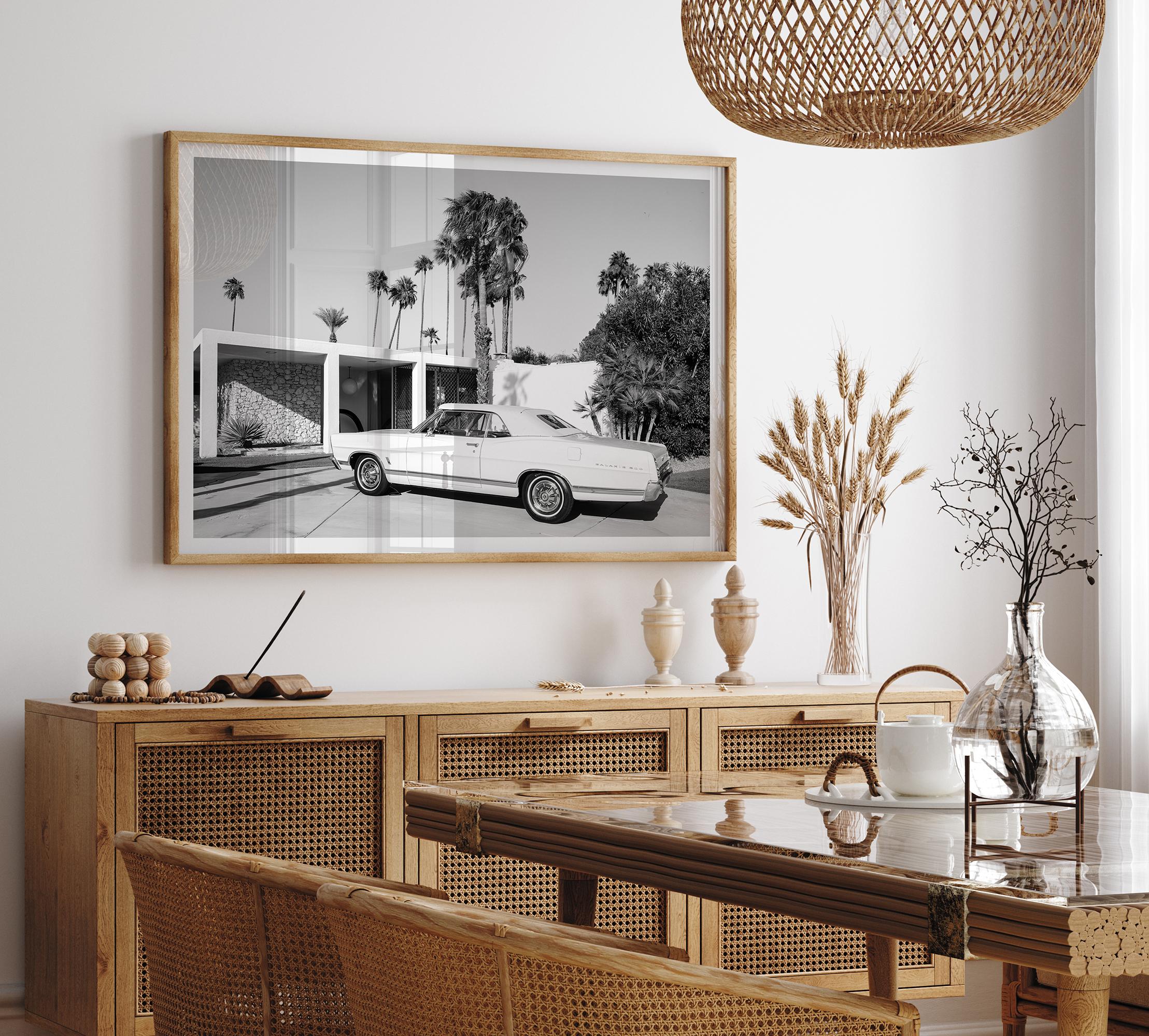Palm Springs artwork featuring a classic vintage car, mid-century modern architecture and tall desert palm trees in black and white.