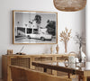 Palm Springs artwork featuring a classic vintage car, mid-century modern architecture and tall desert palm trees in black and white.
