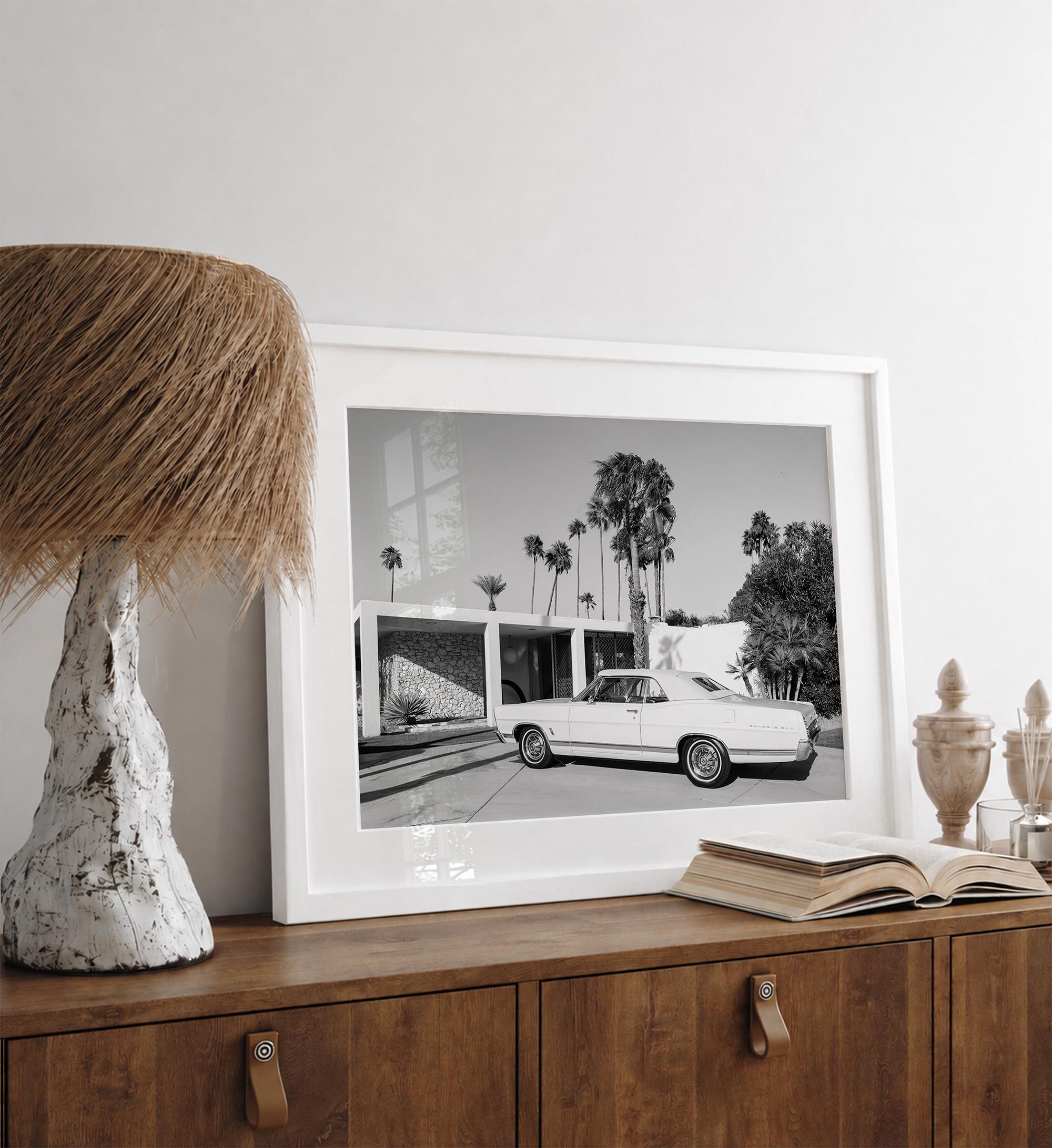 Palm Springs artwork featuring a classic vintage car, mid-century modern architecture and tall desert palm trees in black and white.