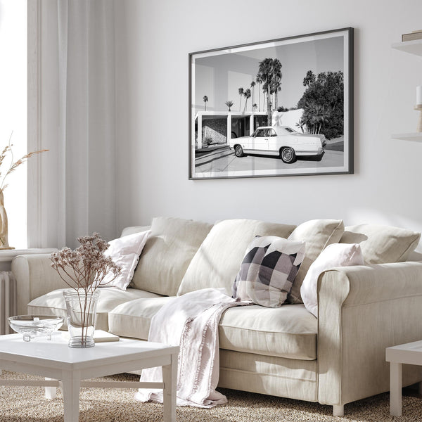 Palm Springs artwork featuring a classic vintage car, mid-century modern architecture and tall desert palm trees in black and white.