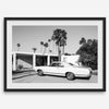 Palm Springs artwork featuring a classic vintage car, mid-century modern architecture and tall desert palm trees in black and white.