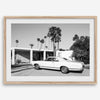 Palm Springs artwork featuring a classic vintage car, mid-century modern architecture and tall desert palm trees in black and white.