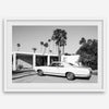 Palm Springs artwork featuring a classic vintage car, mid-century modern architecture and tall desert palm trees in black and white.