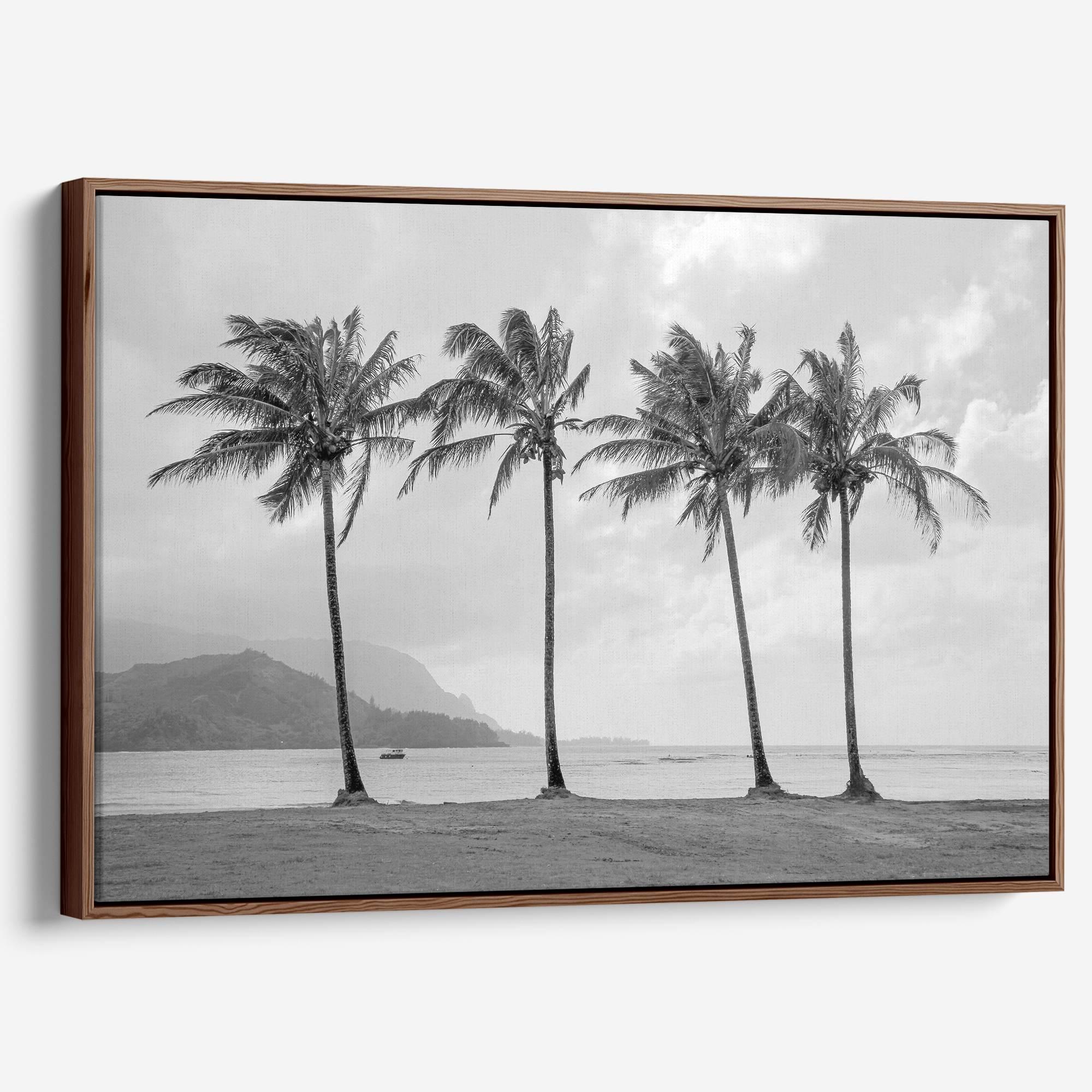 Black and white canvas print of four tall palm trees on Hanalei Bay beach in Kauai, with mountains and cloudy sky in the background.