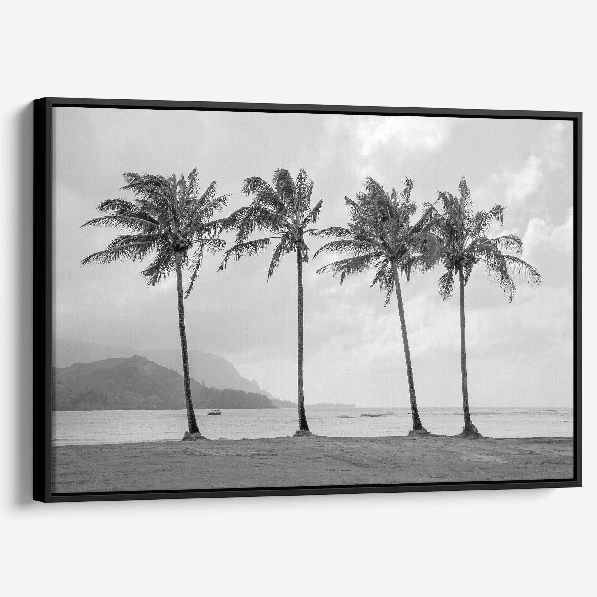 Black and white canvas print of four tall palm trees on Hanalei Bay beach in Kauai, with mountains and cloudy sky in the background.