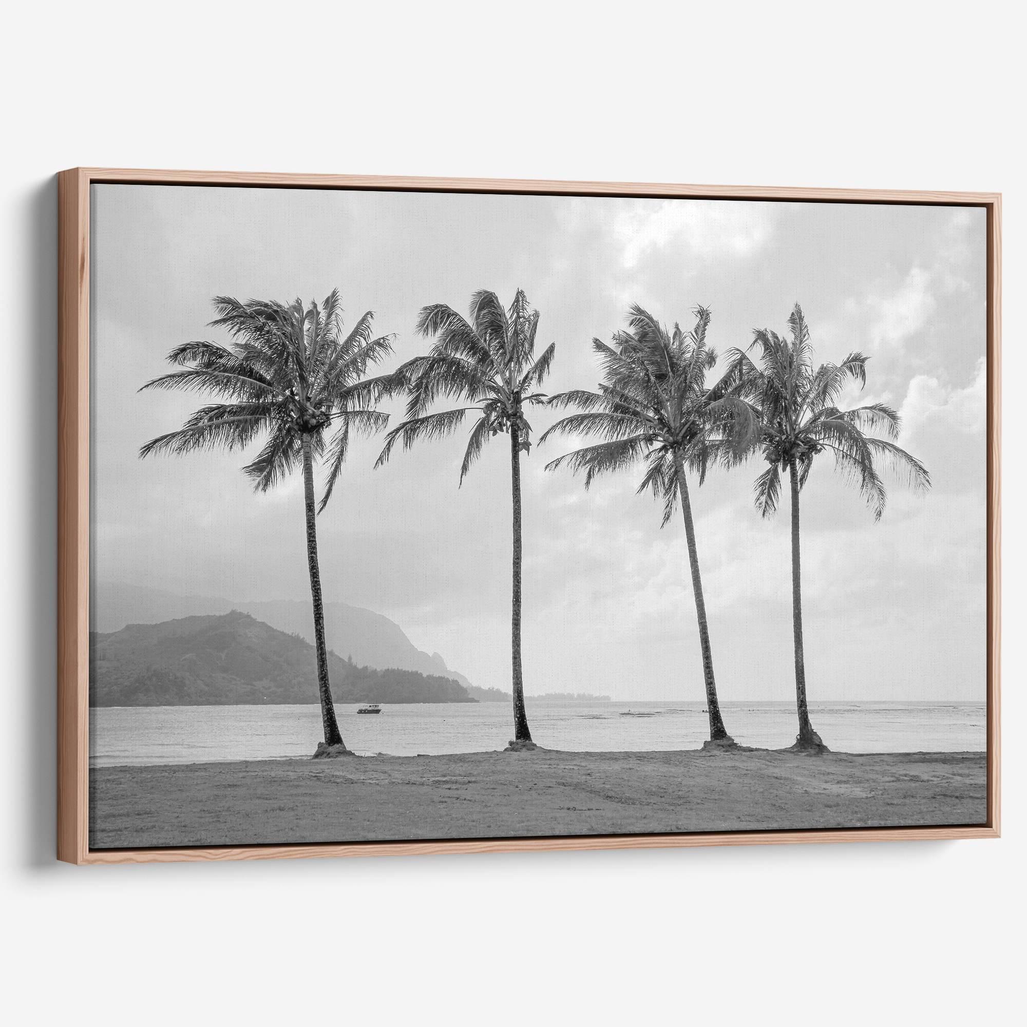 Black and white canvas print of four tall palm trees on Hanalei Bay beach in Kauai, with mountains and cloudy sky in the background.