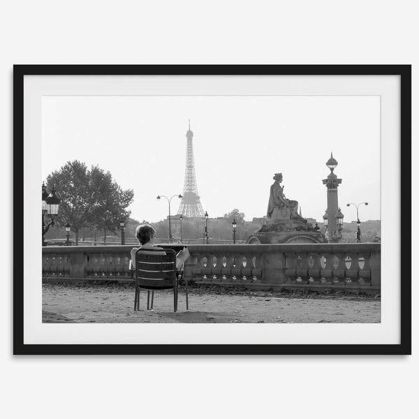Black-and-white Paris wall art featuring a woman reading in a park with the Eiffel Tower in the background.