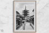 Timeless Kyoto scene with traditional architecture and kimono-clad woman in black and white.