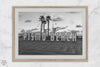 Black and white photo of the Pismo Beach street sign with palm trees and boardwalk – fine art coastal print