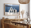 Santorini wall art featuring white church bell towers above the Aegean Sea in Santorini, Greece with volcanic cliffs and sailboats.