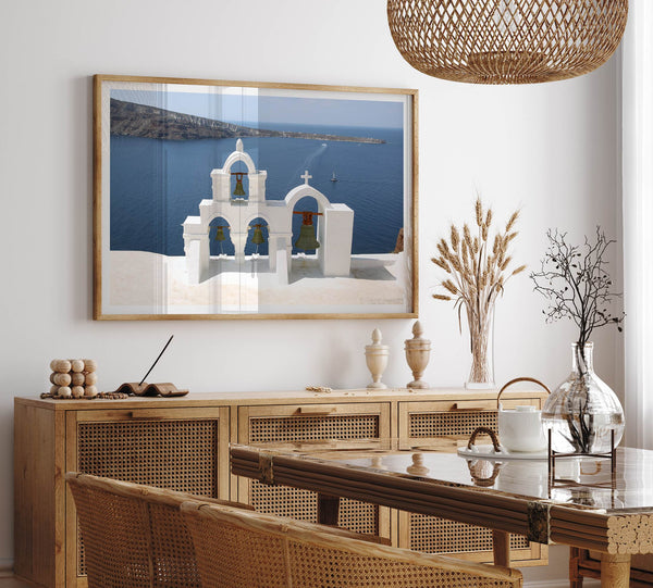 Santorini wall art featuring white church bell towers above the Aegean Sea in Santorini, Greece with volcanic cliffs and sailboats.