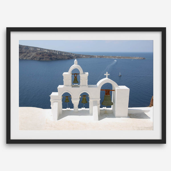 Santorini wall art featuring white church bell towers above the Aegean Sea in Santorini, Greece with volcanic cliffs and sailboats.