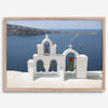 Santorini wall art featuring white church bell towers above the Aegean Sea in Santorini, Greece with volcanic cliffs and sailboats.