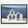 Santorini wall art featuring white church bell towers above the Aegean Sea in Santorini, Greece with volcanic cliffs and sailboats.