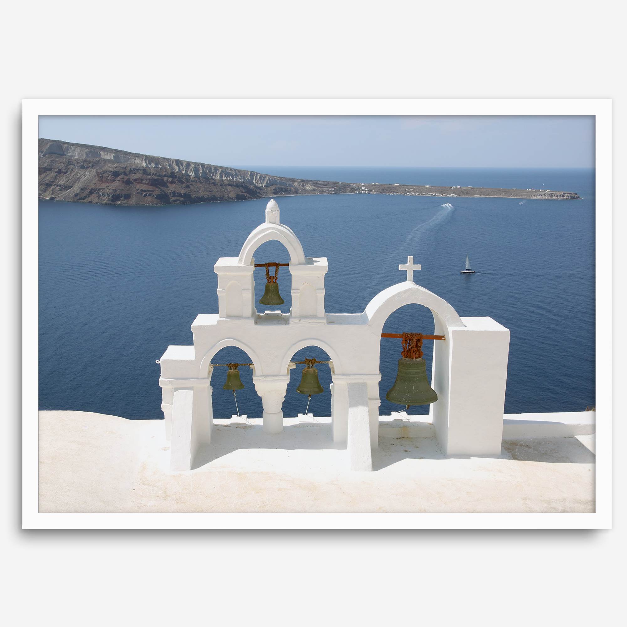 Santorini wall art featuring white church bell towers above the Aegean Sea in Santorini, Greece with volcanic cliffs and sailboats.