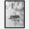 Monochrome ski lift view from below with hanging skis and cloudy mountain sky background.