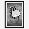 Black and white Florence street photography featuring a vintage bicycle and designer shopping bag near Via della Vigna Nuova