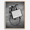 Black and white Florence street photography featuring a vintage bicycle and designer shopping bag near Via della Vigna Nuova