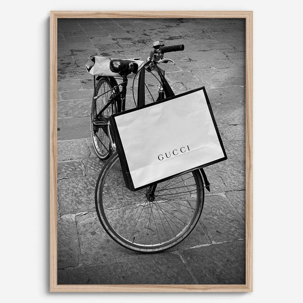 Black and white Florence street photography featuring a vintage bicycle and designer shopping bag near Via della Vigna Nuova