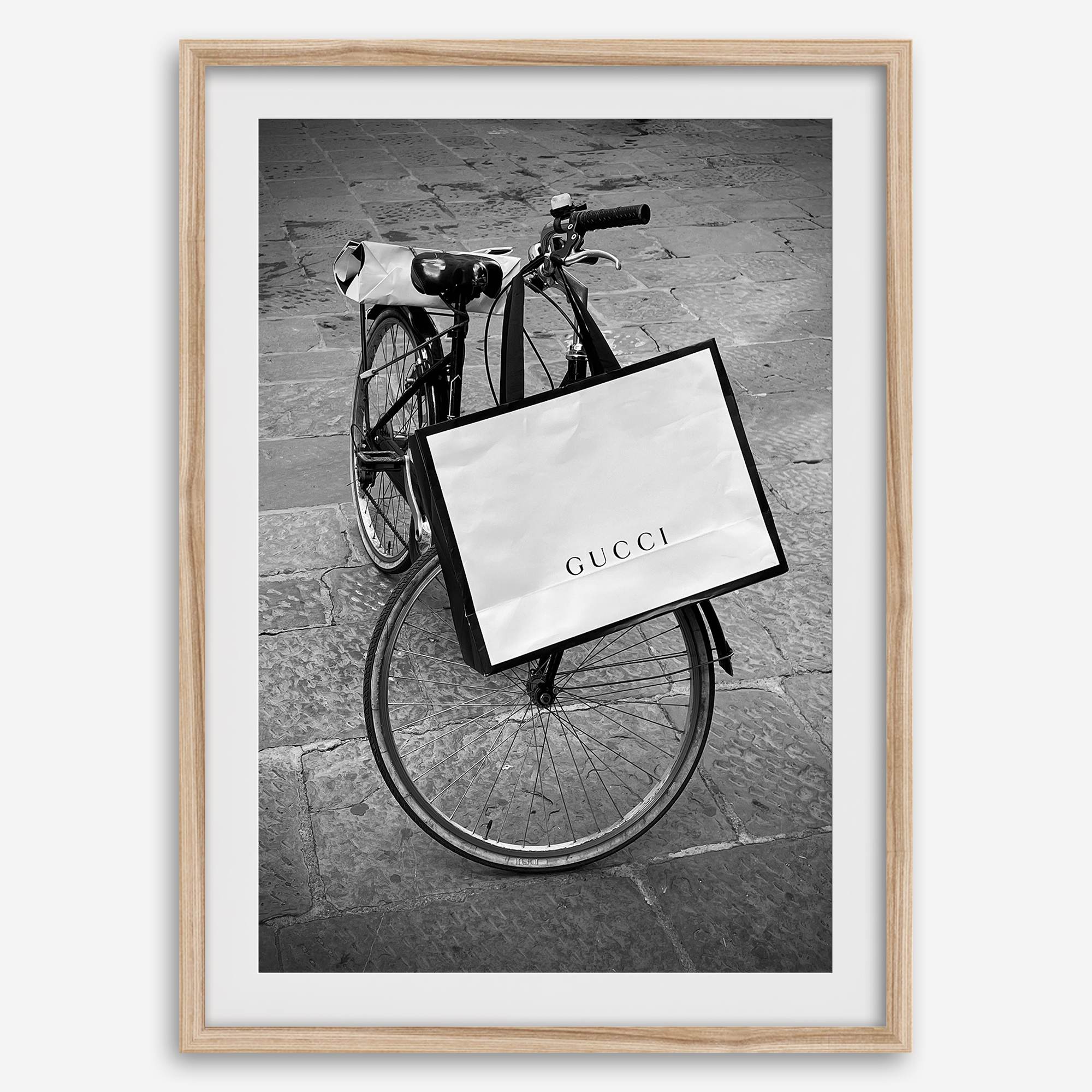 Black and white Florence street photography featuring a vintage bicycle and designer shopping bag near Via della Vigna Nuova