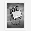 Black and white Florence street photography featuring a vintage bicycle and designer shopping bag near Via della Vigna Nuova