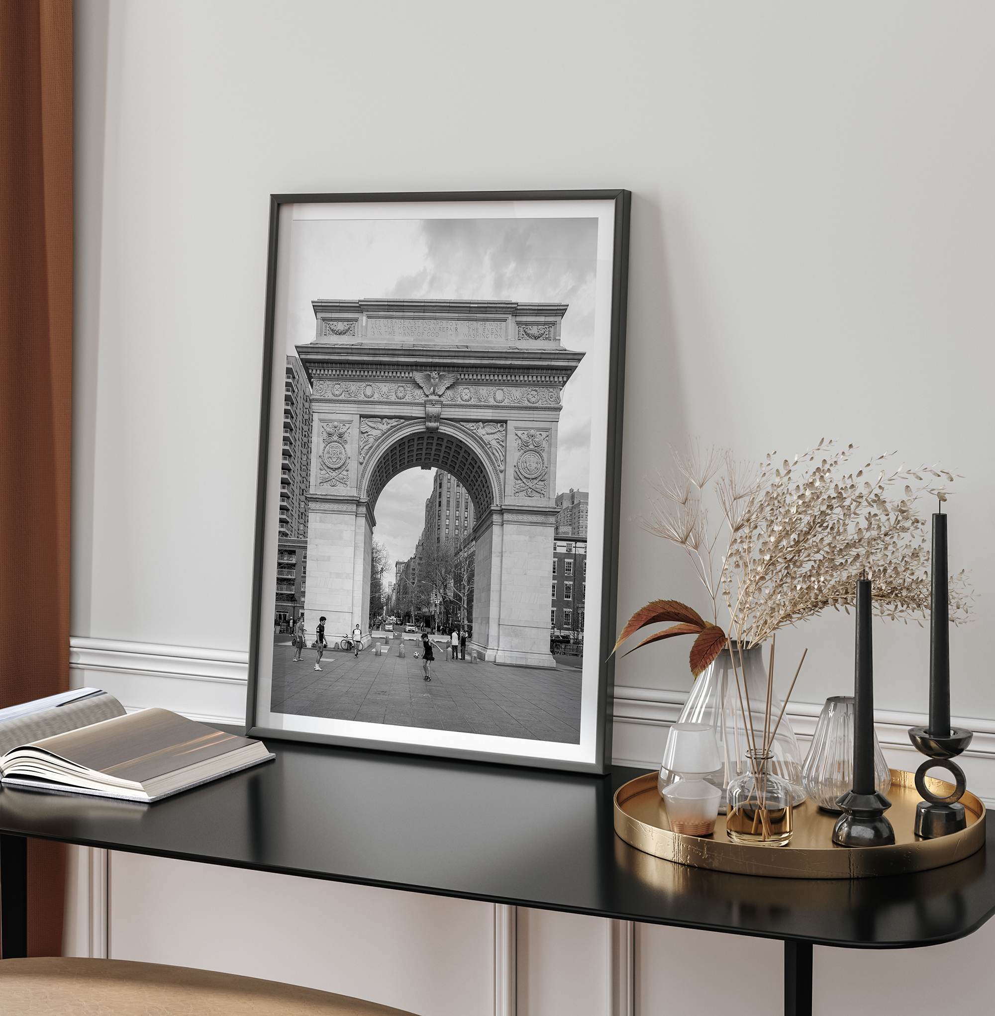 A Black and white architectural photograph print of Washington Square Arch in Greenwich Village, New York City, with people playing soccer in the foreground.